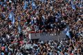 Les supporters argentins attendant le bus avec les joueurs Place de l'Obélisque à Buenos Aires, le 20 décembre 2022. (Photo by Luis ROBAYO / AFP)